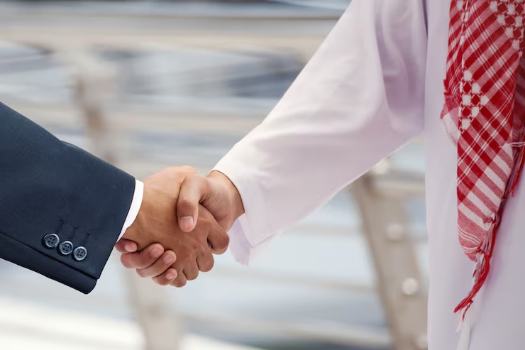 A business executive and a Saudi partner shaking hands